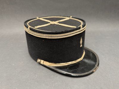 black and gold hat with a cross on it on a gray surface