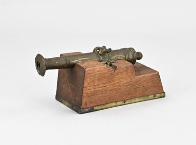 a small wooden box with a cannon on top of it