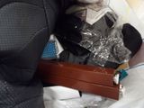 a man in a wet suit holding a suitcase with items in it