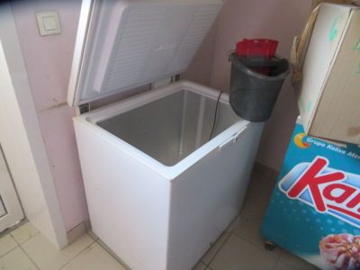a small white chest freezer in the corner of a room