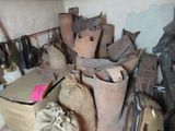 une pile de vieilles chaussures et de sacs dans une pièce