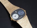 a close up of a gold watch on a black surface