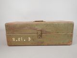 an old green metal box with writing on it sitting on top of a table