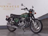 a green motorcycle parked in front of a white wall