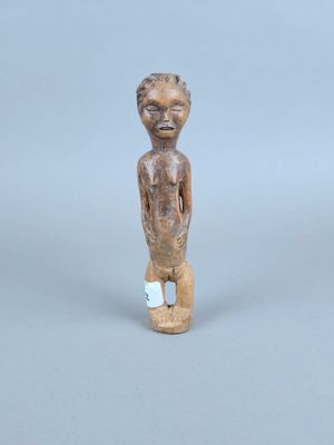 une petite statue en bois représentant un garçon à la petite tête