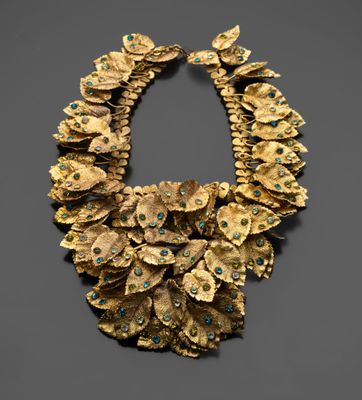 un collier en or orné de pierres turquoise et de feuilles en or
