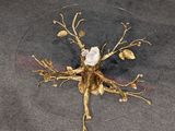 a glass table with a gold leaf and flower decoration on it
