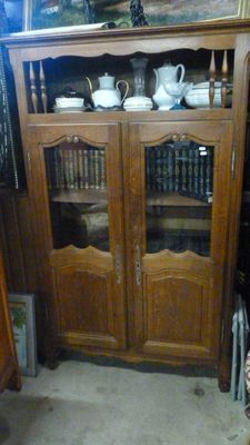 un meuble en bois avec une porte en verre dans une pièce