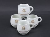 quatre tasses à café blanches ornées d'un « G » doré