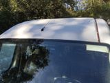 a cat sitting on top of the roof of a car