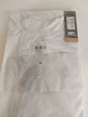 Le t-shirt est blanc et comporte une étiquette noire.