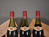 two bottles of wine are sitting on a wooden crate