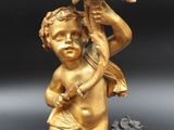an image of a gold statue of a child holding a flower