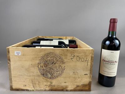 deux bouteilles de vin dans un coffret en bois à côté d'une bouteille de vin