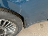 a close up of a blue car with a cat on the wheel