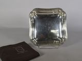 une petite assiette en argent recouverte d'un napperon marron sur la table