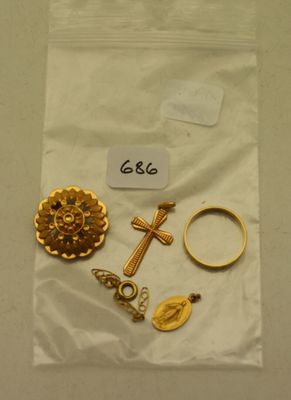 un gros plan sur un sac contenant des bijoux en or orné d'une croix
