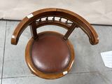 a person standing next to a chair with a brown leather seat