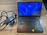 un ordinateur portable posé sur une table, avec une souris et un chargeur