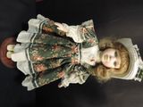 a doll that is wearing a green dress and hat