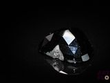 a close up of a black and white diamond on a black surface