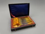 une image représentant un coffret contenant six cuillères en or