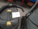 un aspirateur posé par terre à côté d'un sac