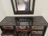 a black and gold dresser with a mirror above it