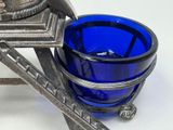a blue glass bowl sitting on top of a metal stand