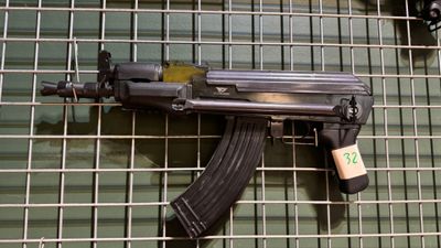 un pistolet accroché à une clôture métallique