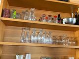 a shelf with many glasses and bottles on it