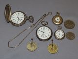 many different types of pocket watches on the table