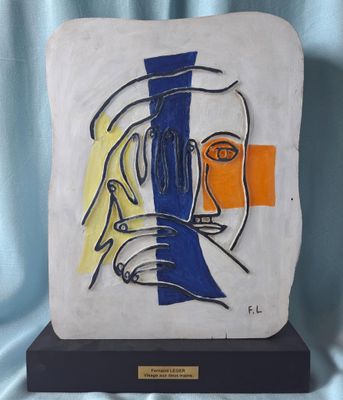 une peinture représentant le visage d'une femme sur une plaque blanche et bleue