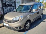 La camionnette est garée sur le bord de la rue, devant un immeuble.