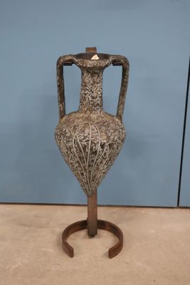 un vase posé sur un socle au sol