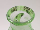 a green glass vase with a green swirl inside of it