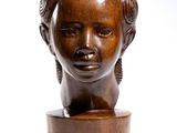 wooden sculpture of a woman ' s head on a wooden stand