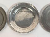 trois plateaux en métal argenté posés sur une table blanche