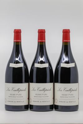 trois bouteilles de vin rouge posées sur une table