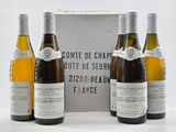 trois bouteilles de vin sont posées devant une boîte