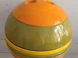 an orange and green bowl sitting on a white table