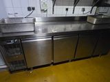 a stainless steel counter top in a kitchen with a refrigerator