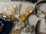 a pile of assorted watches and other items on a table
