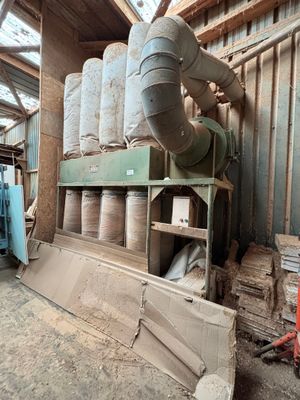 une grande machine qui se trouve dans un bâtiment où sont entreposés de nombreux rouleaux de papier