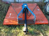 a blue and orange plow sitting in the grass