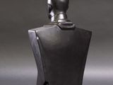 a black sculpture of a woman ' s head on a mannequin