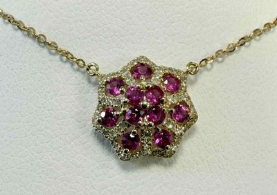 un gros plan d'un collier orné de pierres roses sur un fond blanc