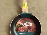 a frying pan with a wooden handle on the floor