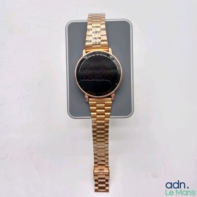une montre en or posée sur un téléphone portable