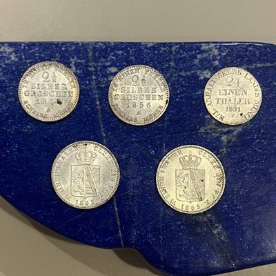 six pièces différentes sont disposées sur un plateau bleu à fond blanc